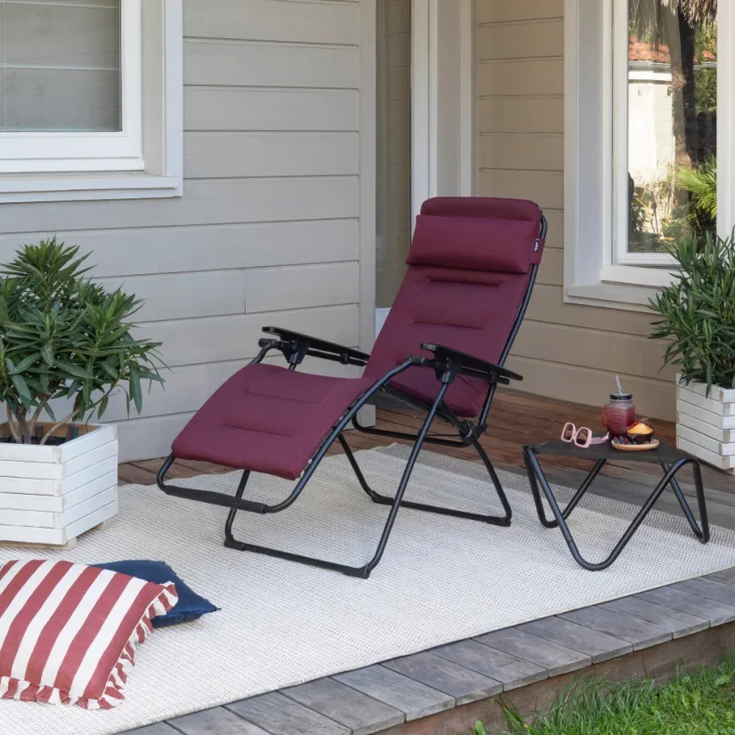 Relaxační křeslo Lafuma FUTURA AirComfort červená na verandě s výhledem do zahrady.